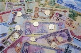 واحد پول دبی؛ تصویری از چند درهم امارات که روی آن‌ها تعدادی سکه قرار دارد.